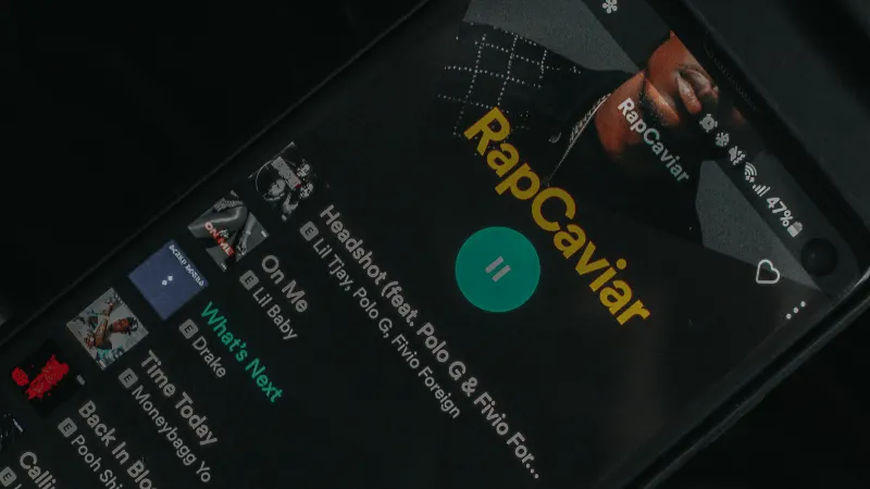 Rapcaviar playlist on a smartphone screen showcasing popular music tracks and streaming app interface for music marketing and