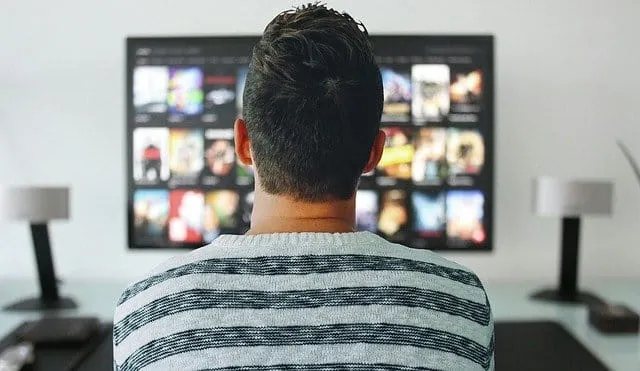 Watching digital media content on a large screen in a modern home entertainment setup.