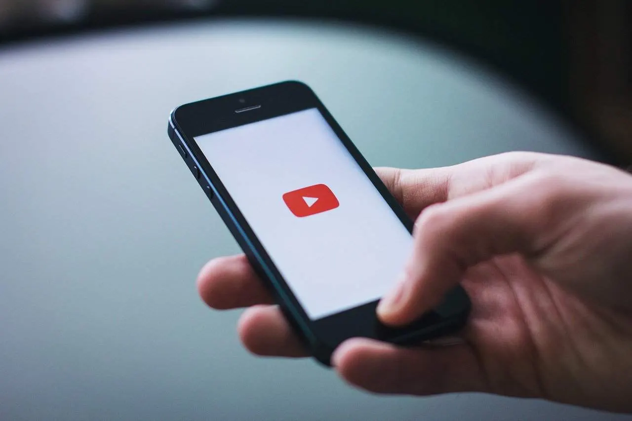 Mobile phone displaying the YouTube app icon for streaming and video content.